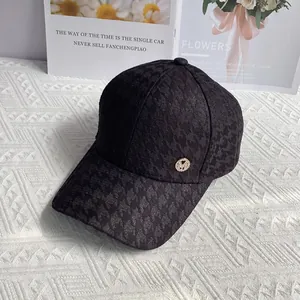 Detail of black houndstooth baseball cap featuring a sparkling gold rhinestone M logo