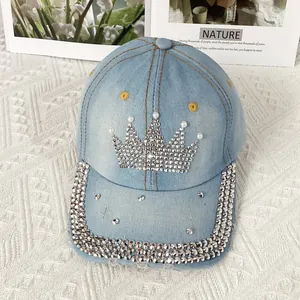 Détail d'une casquette de baseball en jean bleu clair avec couronne en strass et perles