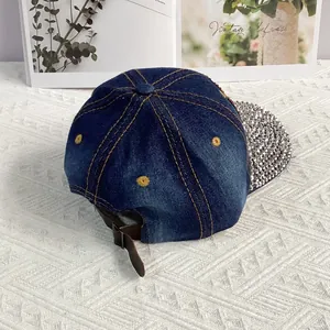 Detail der blauen Denim-Baseballkappe mit Strass-Krempe und Lederband hinten
