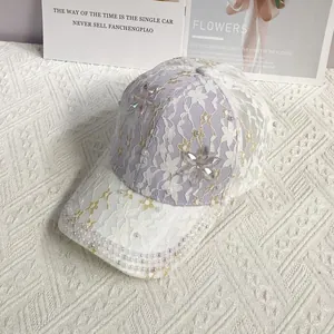 Détail d'une casquette en dentelle violette avec perles blanches et fleurs en cristal