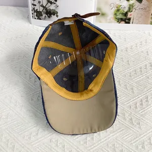 Detail der Jeans-Baseballkappe mit goldenem Schweißband und verstellbarem Lederriemen