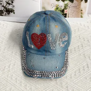 Détail du logo LOVE en strass et bordure en cristal sur casquette en jean vintage
