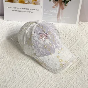 Détail de la dentelle blanche avec perles et fleur en cristal sur une casquette pour femmes
