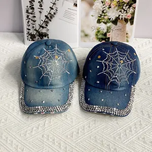Détail de casquettes en denim avec motif toile d'araignée en strass bleu clair et foncé
