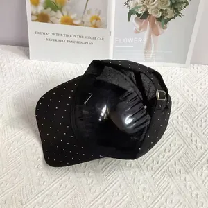 Detail of black baseball cap with metal buckle strap and white polka dot rhinestones