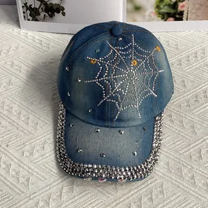 Gros plan sur une casquette en jean avec motif toile d'araignée en strass et broderie