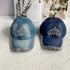 Vue détaillée de casquettes en jean avec motifs de couronne en strass et bords vieillis