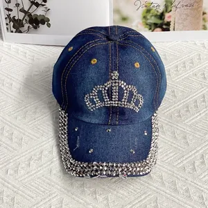 Détail de la couronne en strass et bordure sertie sur une casquette en jean bleu