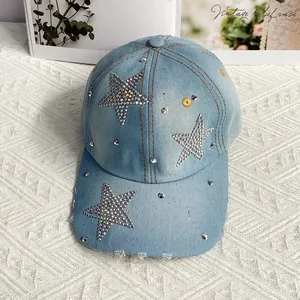 Détail d'étoiles en strass et de clous métalliques sur une casquette en jean bleu clair