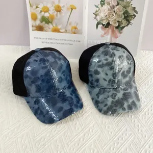 Detail view of mesh baseball caps with sequin leopard print in royal blue and grey-green