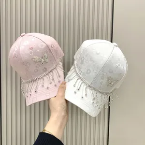 Detail of floral jacquard baseball cap with sparkling butterfly and long rhinestone tassels
