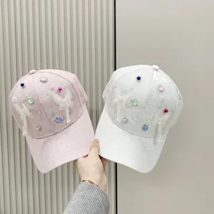 Detail of butterfly baseball cap with colorful rhinestones, pearls and fringe pendant