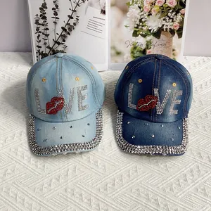 Détail de casquettes en jean bleu clair et foncé avec motif LOVE en strass et lèvres rouges