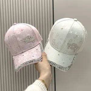 Detail of floral jacquard baseball caps with heart rhinestone and studded brims