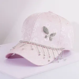 Close-up of pink lace baseball cap featuring a crystal butterfly and rhinestone tassels