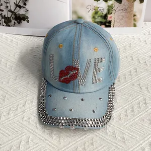 Détail de la casquette en jean bleu clair avec lettrage LOVE en strass et cristaux brillants