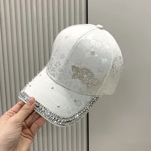 Close-up of white lace floral baseball cap with rhinestone butterfly and studded brim