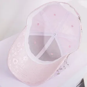 Detailed interior of pink lace baseball cap showing sweatband and rhinestone tassels