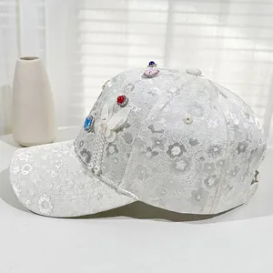 Close-up of floral lace baseball cap with butterfly patch and colorful rhinestones