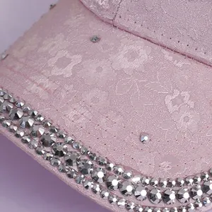 Macro detail of floral embroidery and sparkling rhinestones on pink satin baseball cap