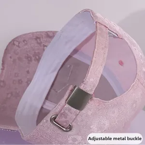 Detail of the pink satin baseball cap featuring an adjustable metal buckle for custom fit