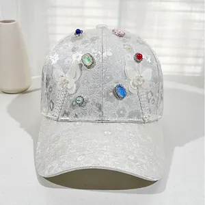 Close-up of floral lace baseball cap featuring colorful gemstones and 3D butterfly charms
