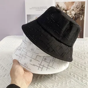 Details von Strass-Geometriemustern auf schwarzen und weißen Flat-Top-Anglerhüten