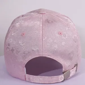 Close-up of pink satin baseball cap with floral jacquard and adjustable back strap