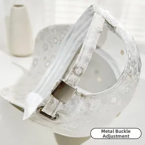 Dettaglio del cappellino jacquard bianco con fibbia in metallo regolabile sul retro