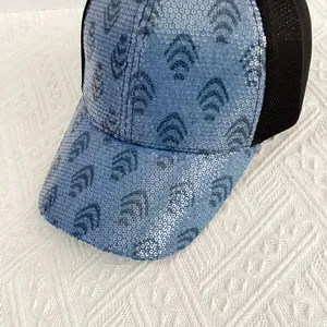 Close-up of blue sequined mesh baseball cap with geometric ripple pattern and breathable net