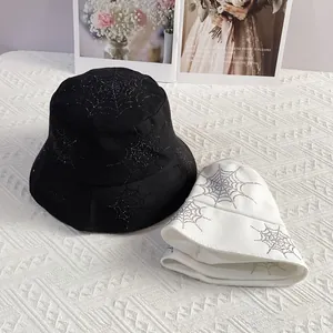 Close-up of sparkling rhinestone spider web pattern on black and white bucket hats