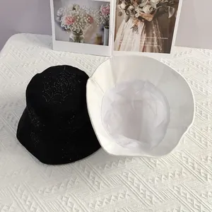 Detail of black rhinestone spider web bucket hat and white mesh lining structure