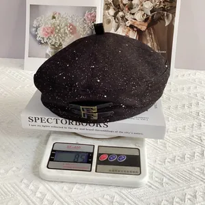 Detail showing the lightweight 85g black beret on a scale with vintage buckle and fabric