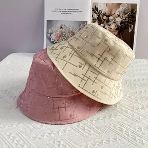 Detailsicht der geometrischen Strassmuster auf rosa und beigen Baumwoll-Anglerhüten