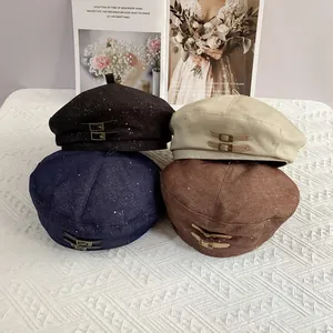 Close-up of stylish berets in four colors with shimmering silver silk and metal buckle details
