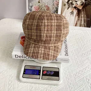 British plaid newsboy cap weighing approximately 105g on a scale to show its lightweight feel