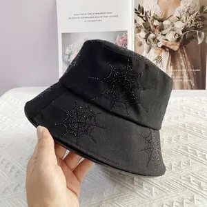 Detailed close-up of a black bucket hat with rhinestone spider web pattern