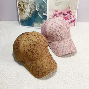 Nahaufnahme der Strass M-Logo und Rautenmuster auf braunen und rosa Baseballkappen