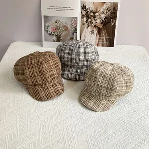 Detailed view of three vintage plaid newsboy caps with sparkling rhinestones on fabric