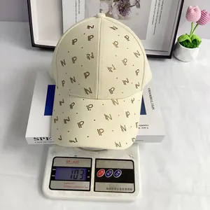 Détail de casquette beige avec lettres en strass étincelants et visière incurvée élégante