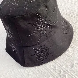 Close-up of black cotton bucket hat featuring intricate rhinestone spider web patterns