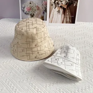 Detail von trendigen Fischerhüten mit Strassblumenmustern in Beige und Weiß für Damen