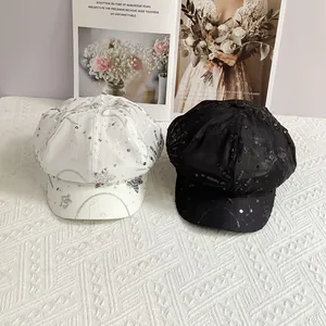 Detailed view of sequined star embroidery on mesh newsboy caps in black and white