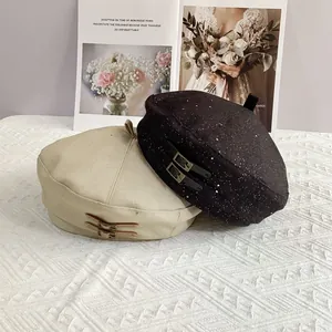 Detail of vintage berets with leather buckle straps on textured white cloth