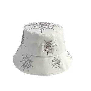 White cotton bucket hat with sparkling rhinestone spider web patterns on white background