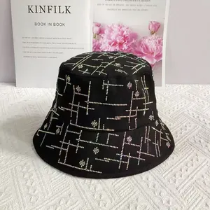 Detail eines schwarzen Fischerhuts mit bunten Strass-Gittermustern und floralen Akzenten