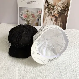 Detailed view of sequined mesh baker boy caps in black and white with star patterns