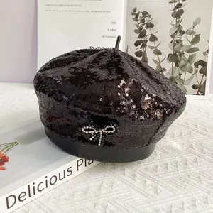 Détail d'un béret noir à paillettes orné d'un nœud étincelant en strass argentés élégants