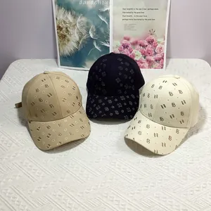 Détail de casquettes de baseball en kaki, noir et beige avec motifs d'étoiles et de B