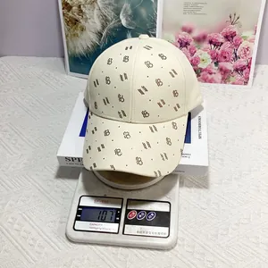 Détail montrant la casquette beige pesant 107g sur une balance pour la précision du poids